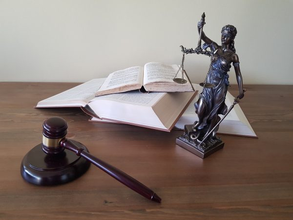 Kostenlose Erstberatung Arbeitsrecht: Justitia, Richterhammer und juristische Literatur als Illustration